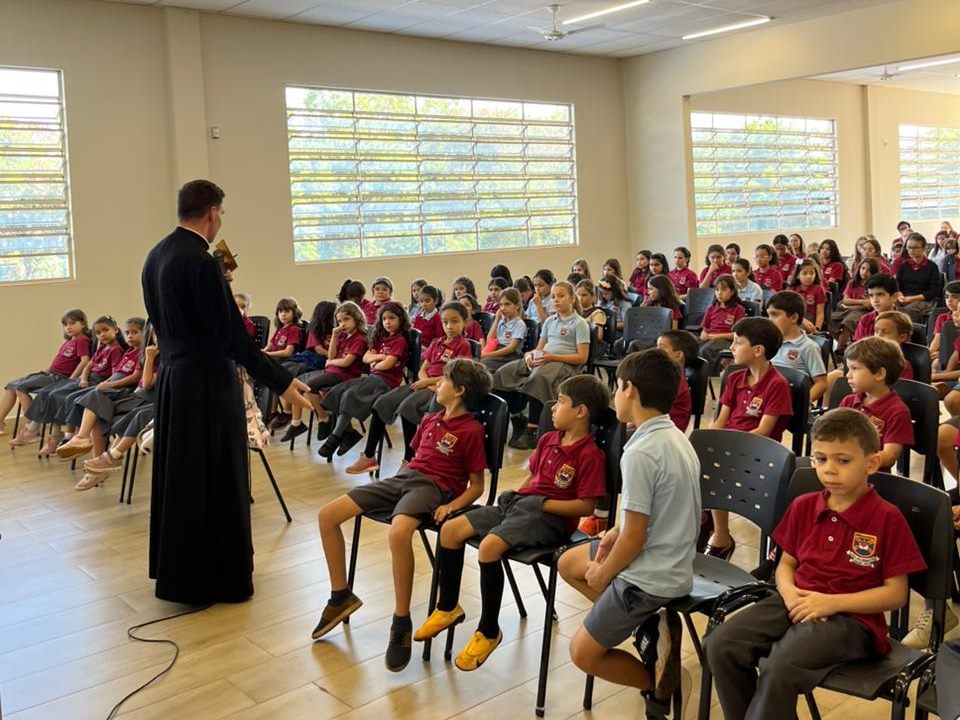 Sacerdote em momento de formação com os alunos reunidos