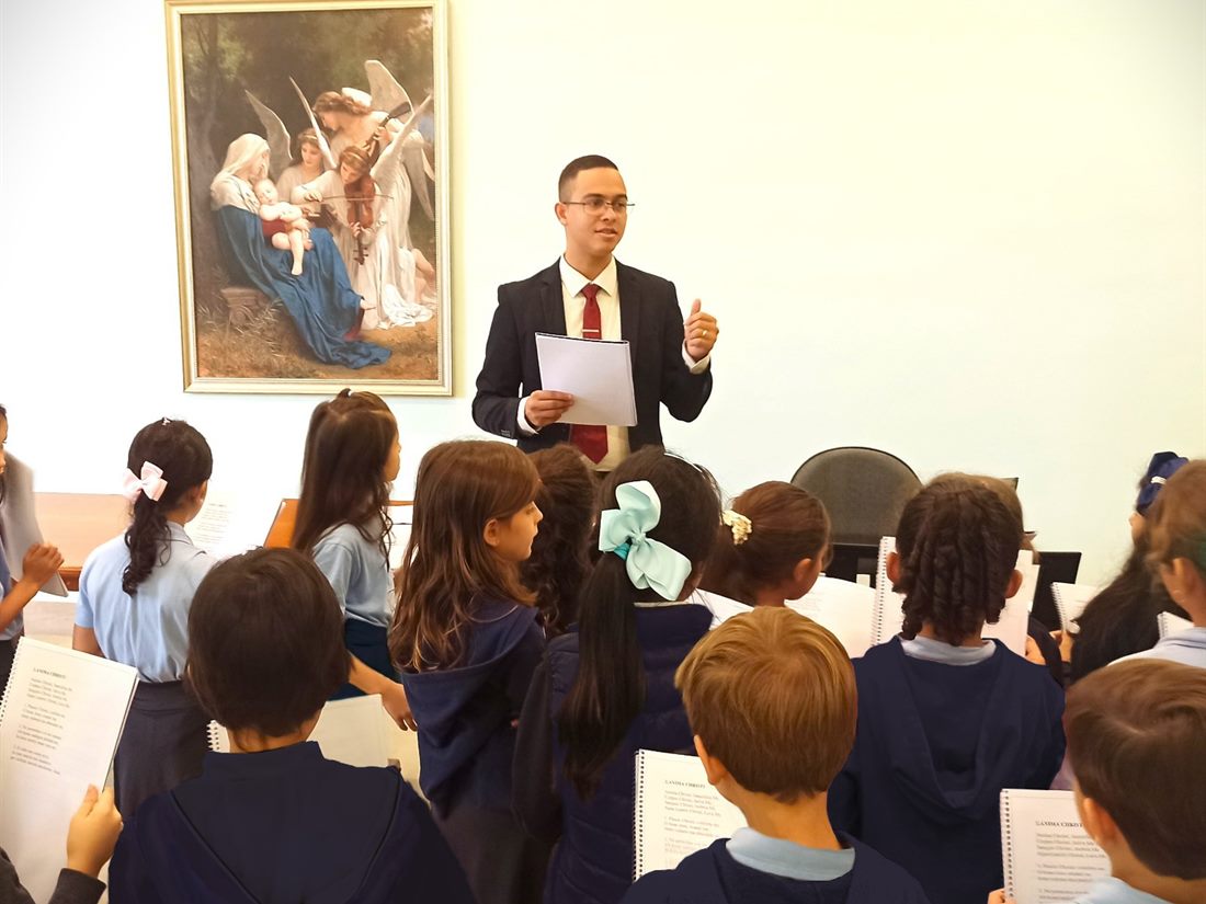 Alunos em aula de canto, acompanhando a partitura