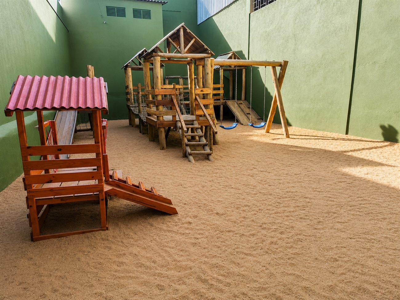 Parquinho de madeira sobre areia, da Educação Infantil