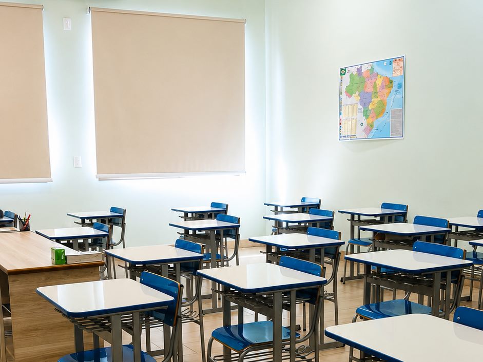 Sala de aula com carteiras individuais e mapa do Brasil
